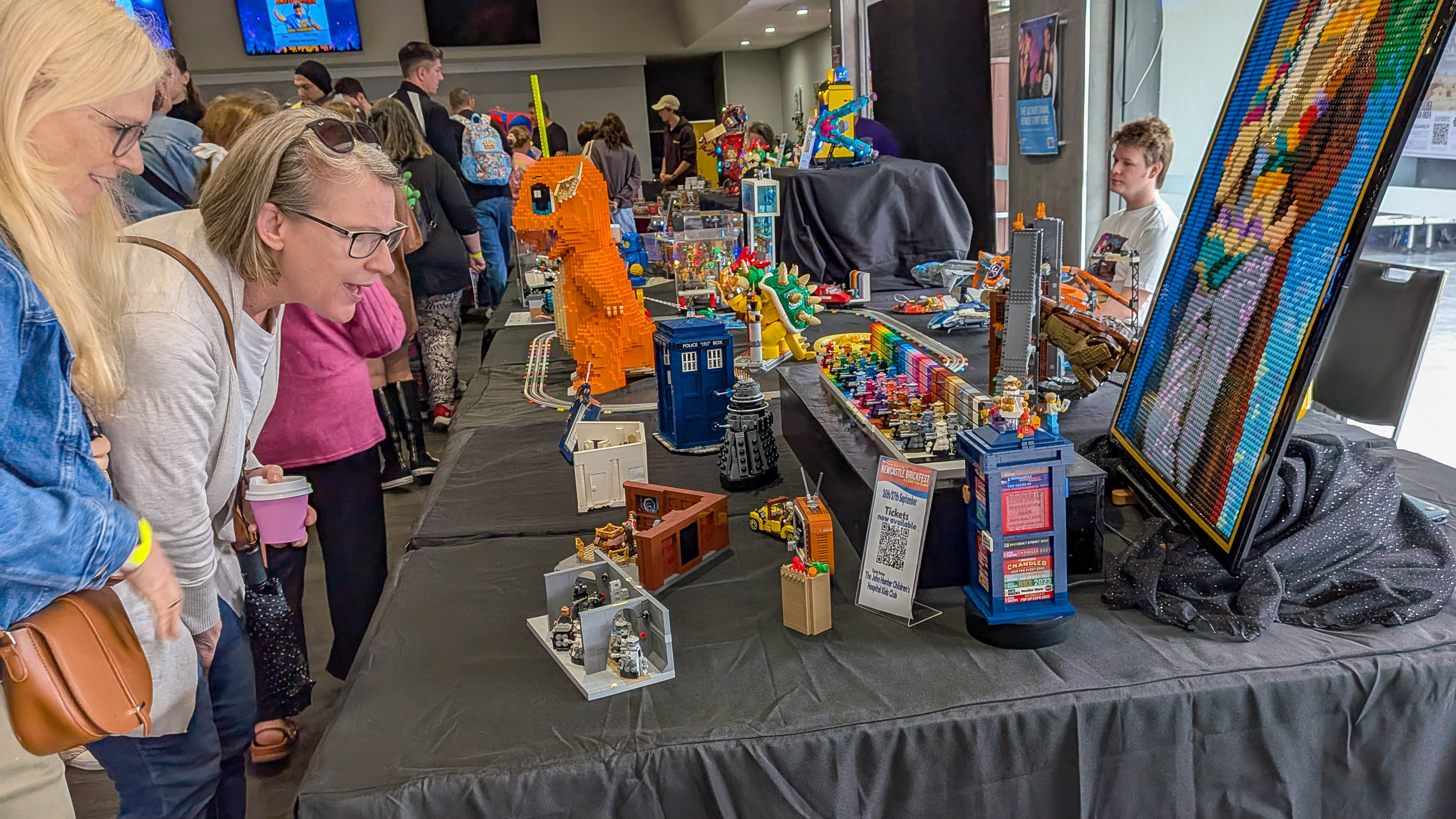 Visitors admiring a large LEGO Charmander, Doctor Who TARDIS, and mosaic art at Central Coast Comicon