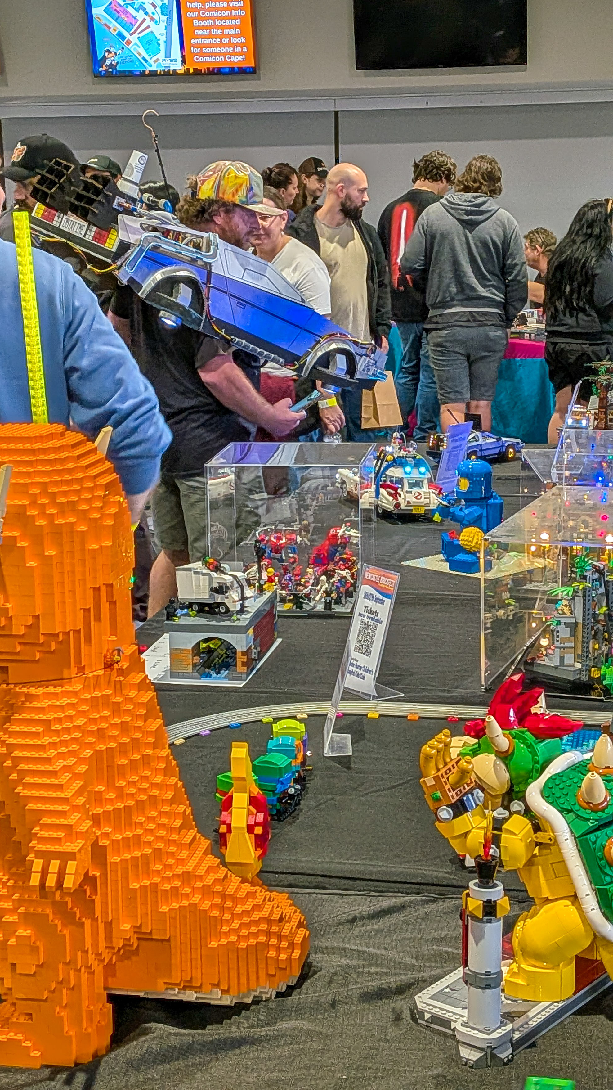 Large LEGO Bowser and Charmander figures on display with Comicon crowds in the background