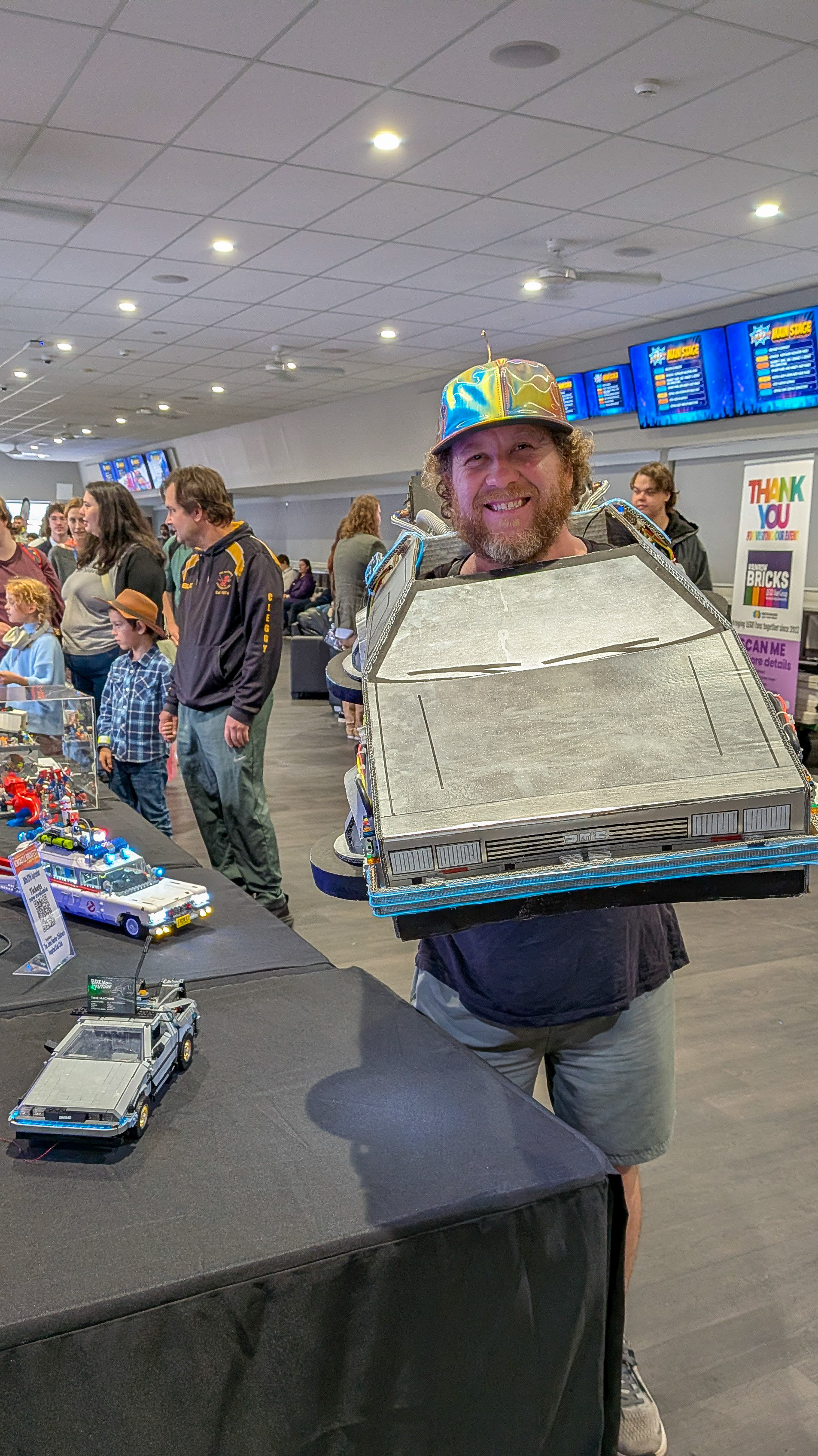 A happy cosplayer wearing a wearable Back to the Future DeLorean costume