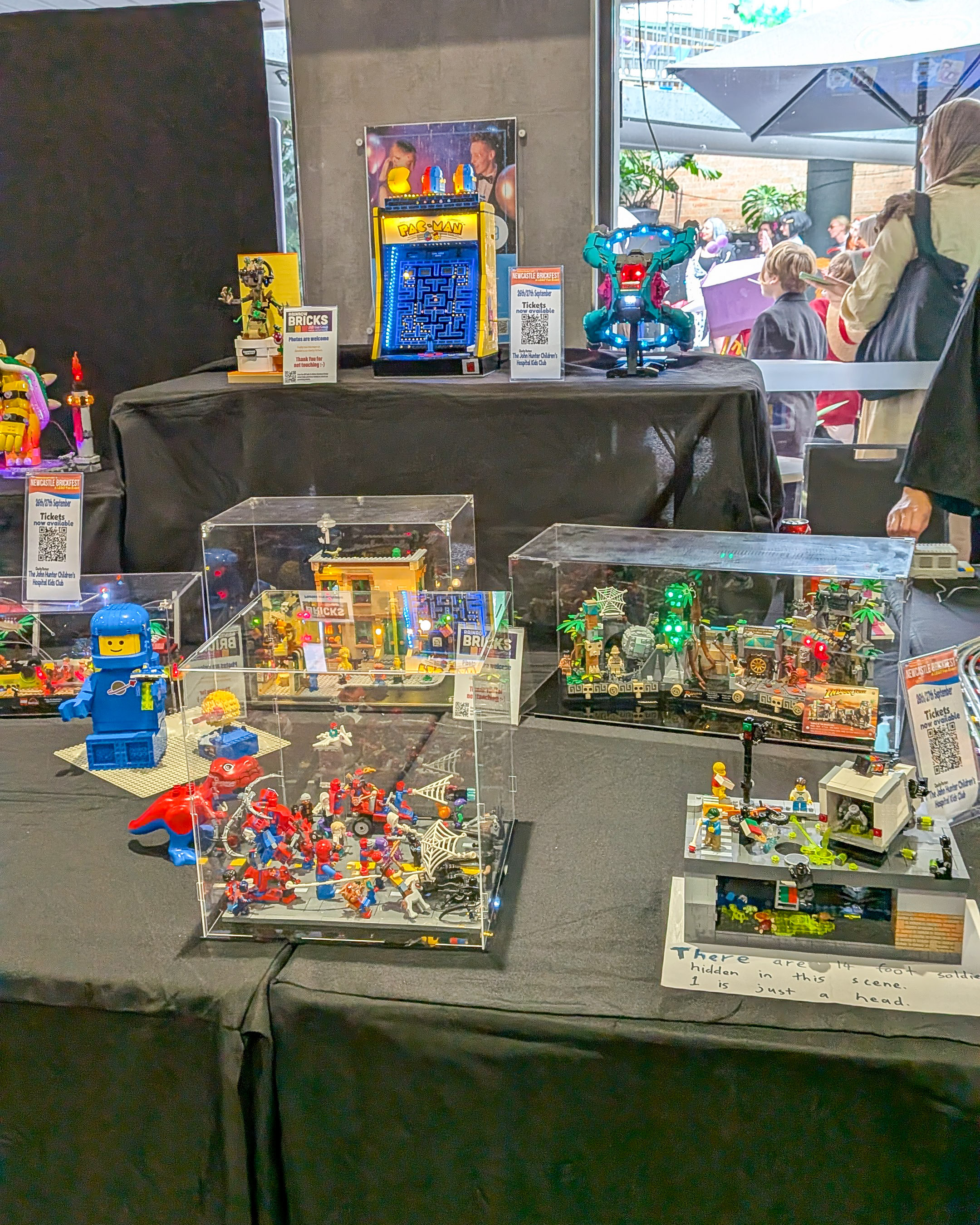 A classic Pac-Man arcade LEGO set and custom MOCs on display in protective cases