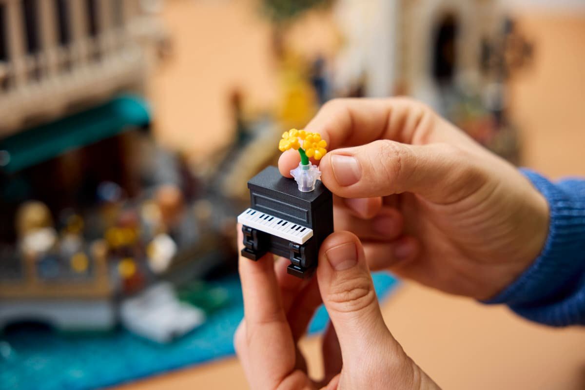 A hand holding the small 3D-printed piano and turning the flower vase