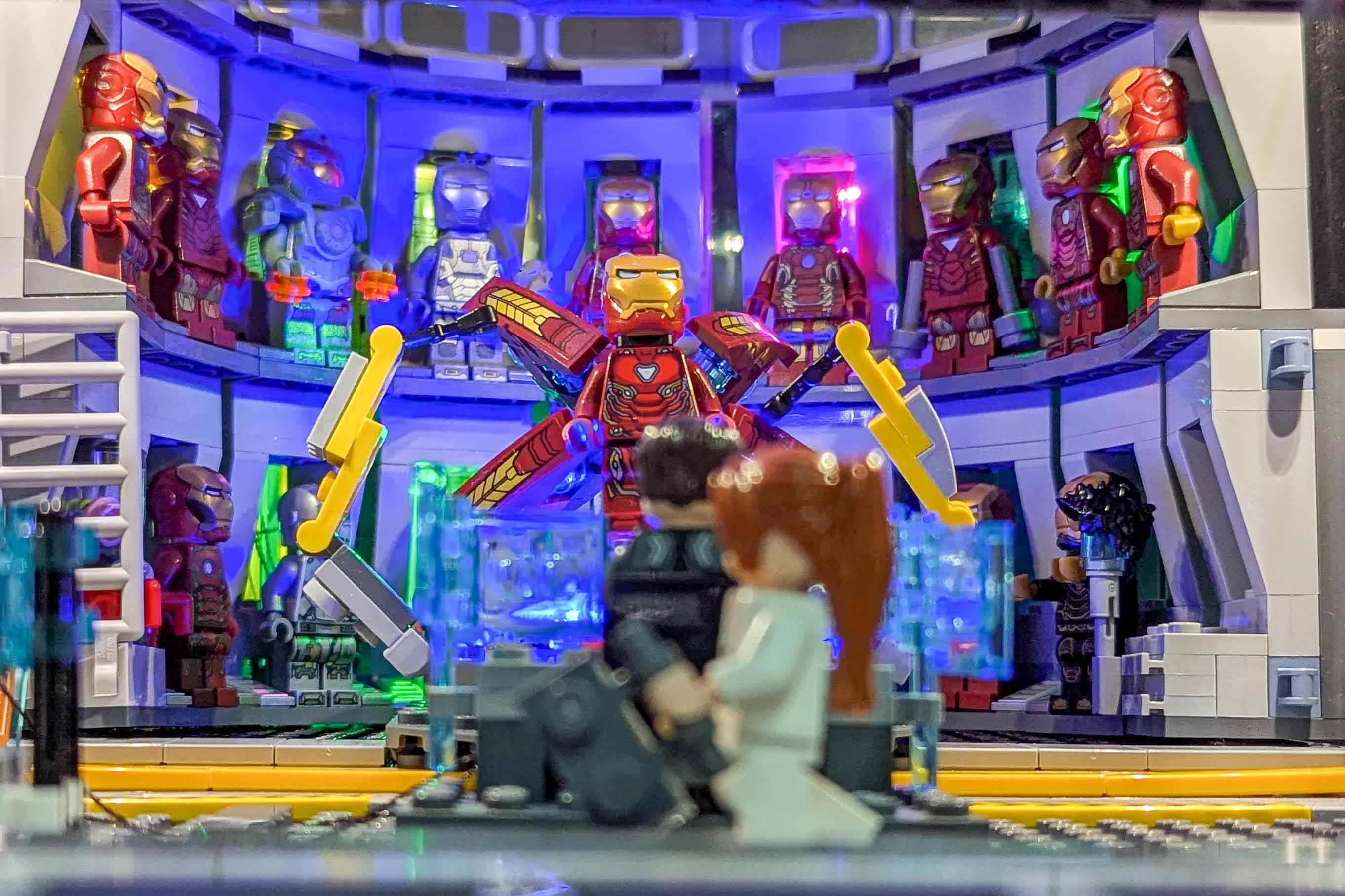 Inside the Avengers Tower: a hall of Iron Man armour minifigures lit in blue, pink and green